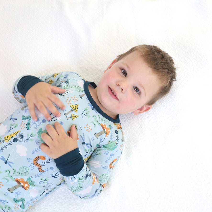 Adorable child in Critter Hollow Crescent Zipp Jammies, featuring playful animal prints, perfect for cozy sleep.