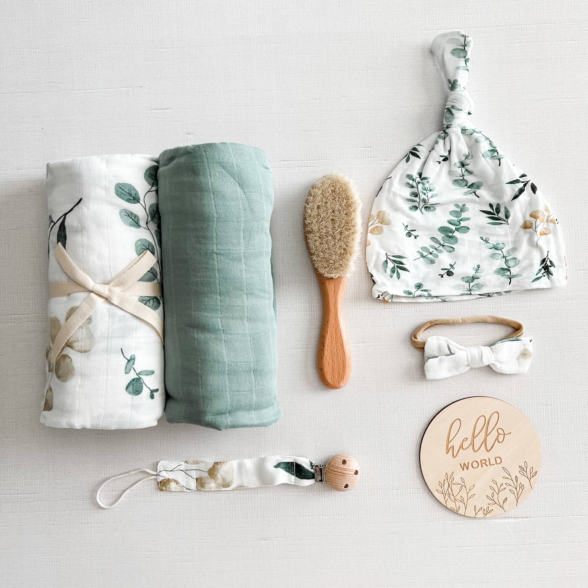 Coco Stripes Eucalyptus Baby Shower Gift Set with bamboo-cotton items: swaddles, hat, brush, and accessories in a neutral palette.