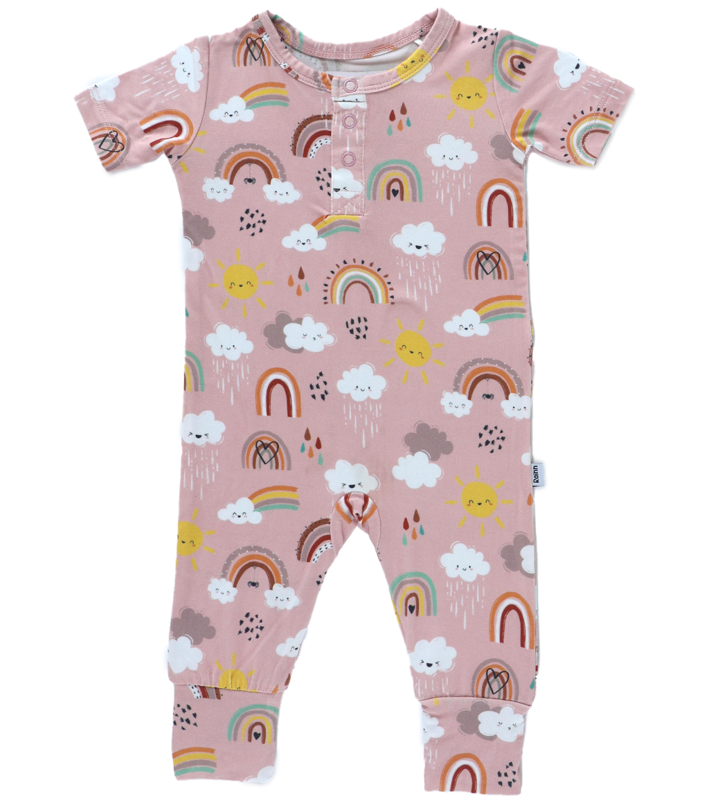 Adorable pink pull-up romper with rainbows and clouds for babies, made from soft bamboo fabric.