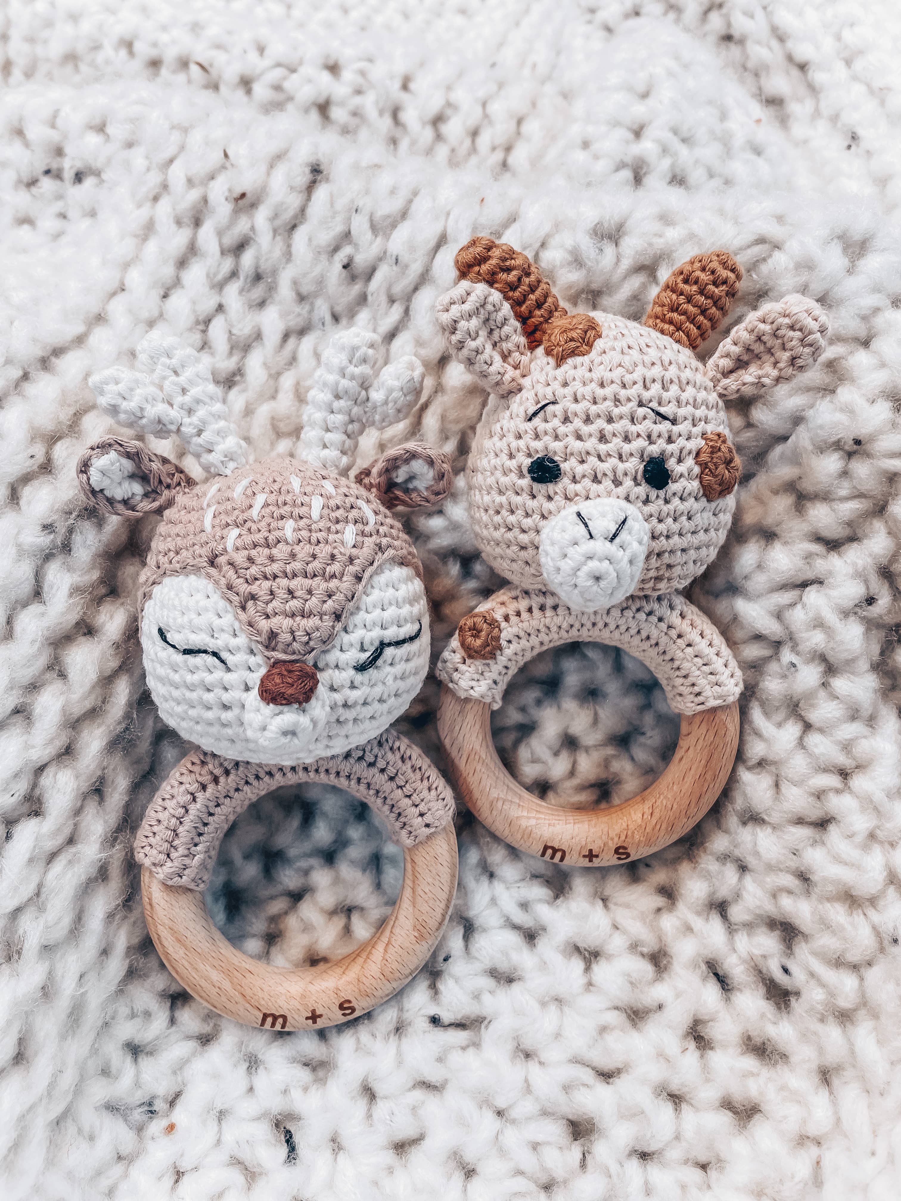 Handmade crochet rattles featuring a deer and giraffe design, perfect sensory toys for babies by Marlowe and Sage.