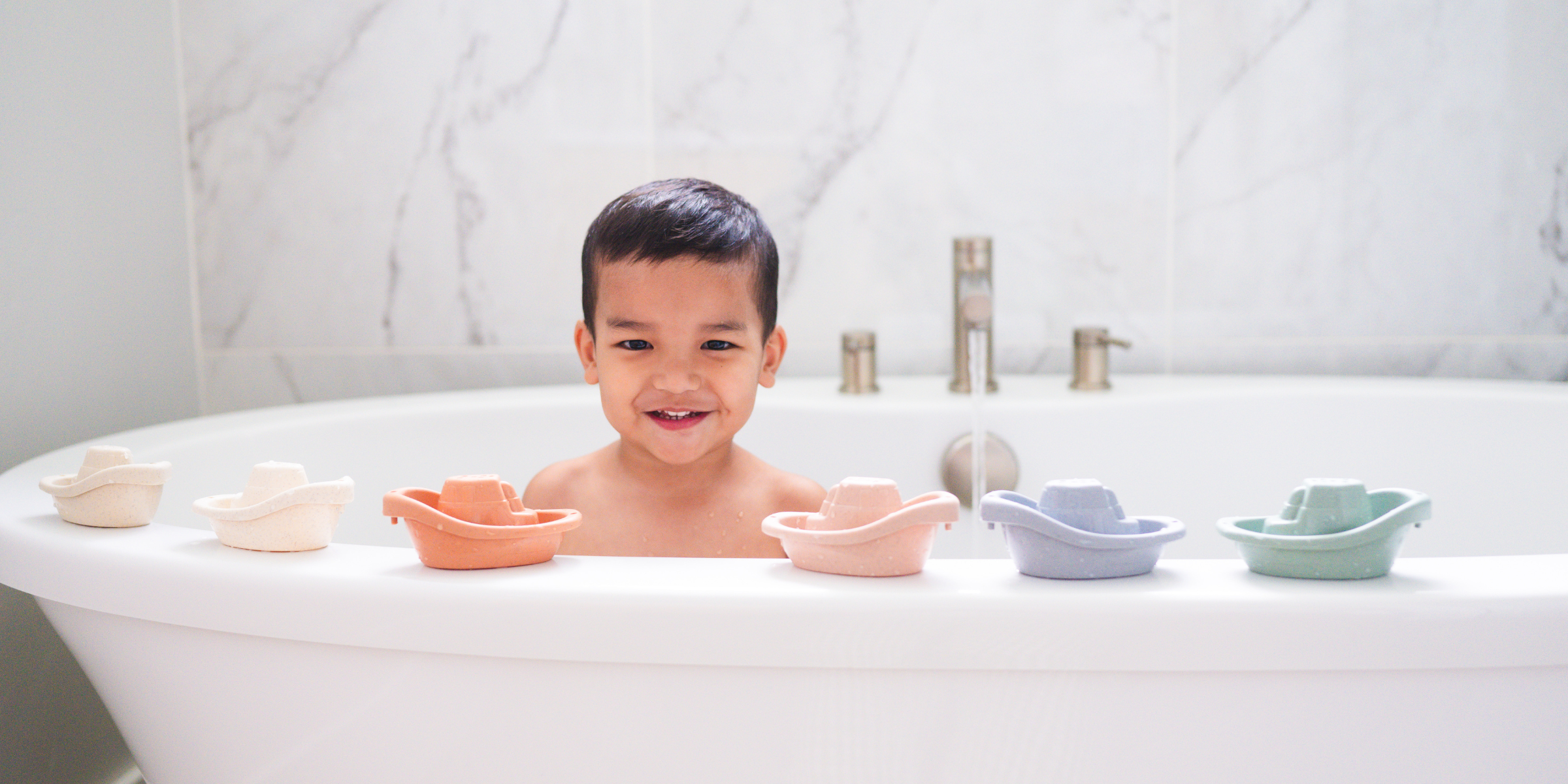 Child playing with Bug + Bean Kids eco-friendly wheat straw boats in bathtub