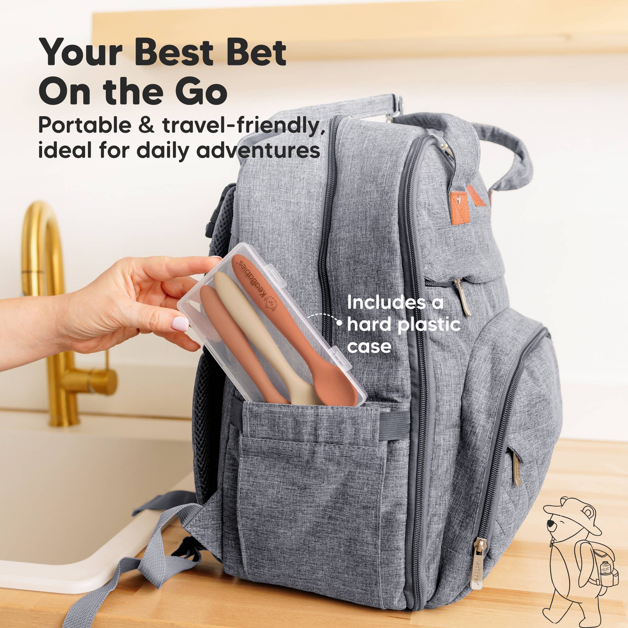 Hand placing KeaBabies Silicone Baby Spoons in travel case into gray diaper bag pocket.