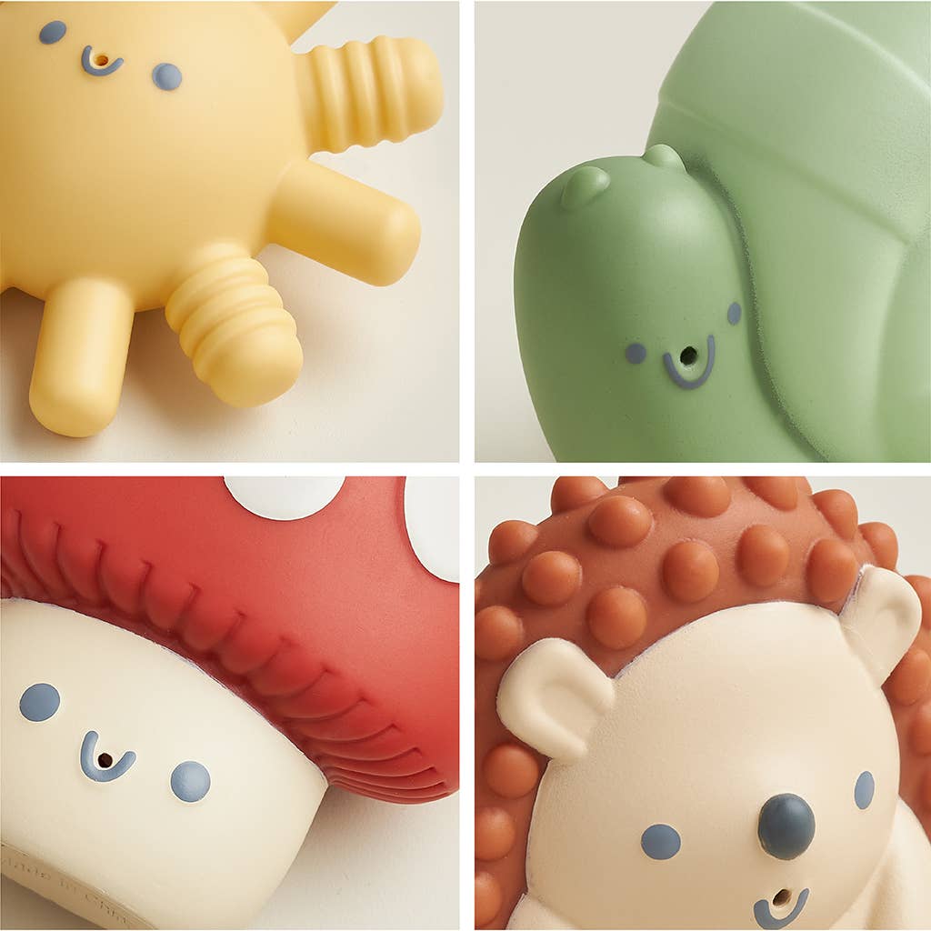 Four colorful Itzy Squirt™ soft bath toys including a sun, snail, mushroom, and hedgehog for bath time fun.