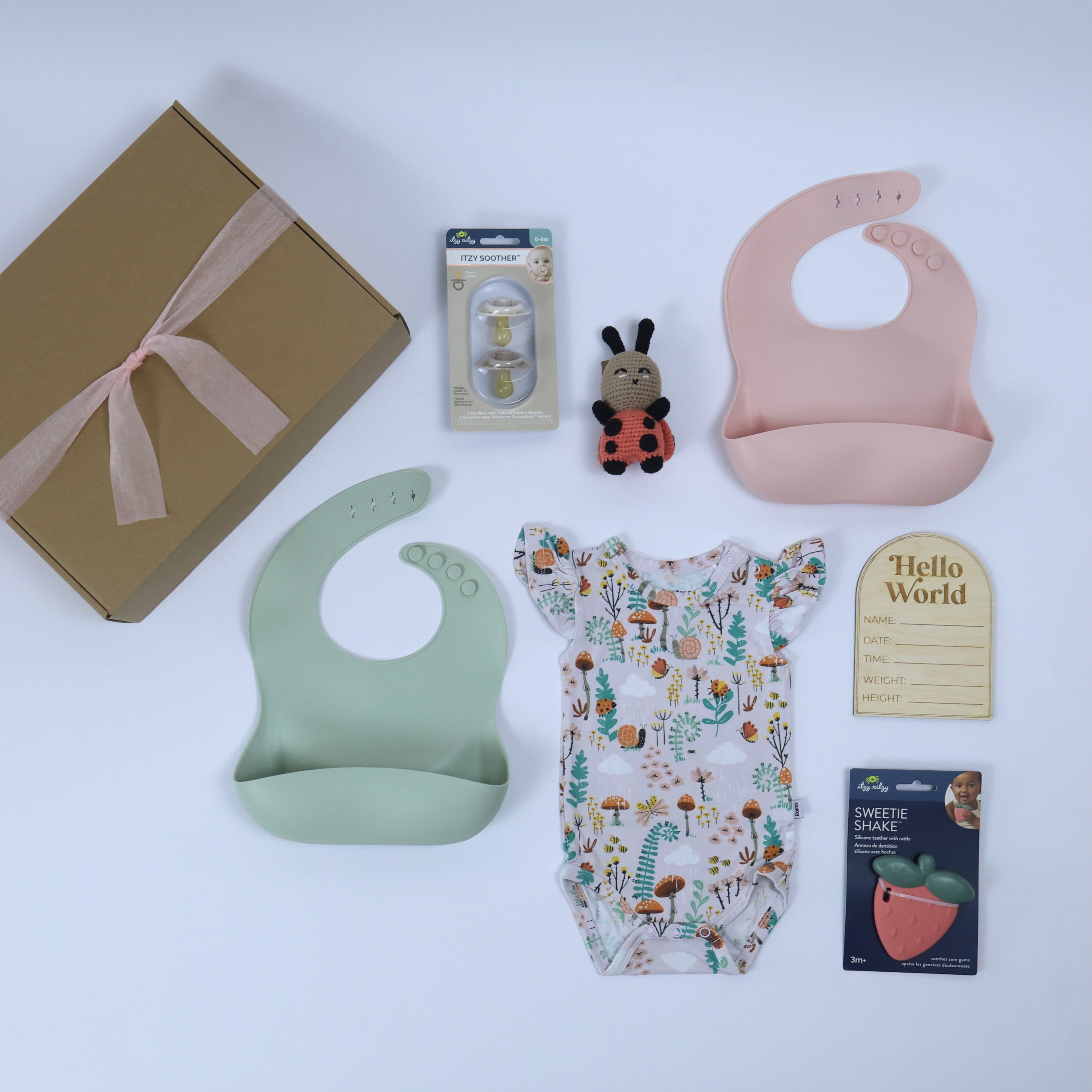 Baby gift set featuring bamboo bodysuit, silicone bibs, rattles and keepsake, perfect for little ones' adventures.