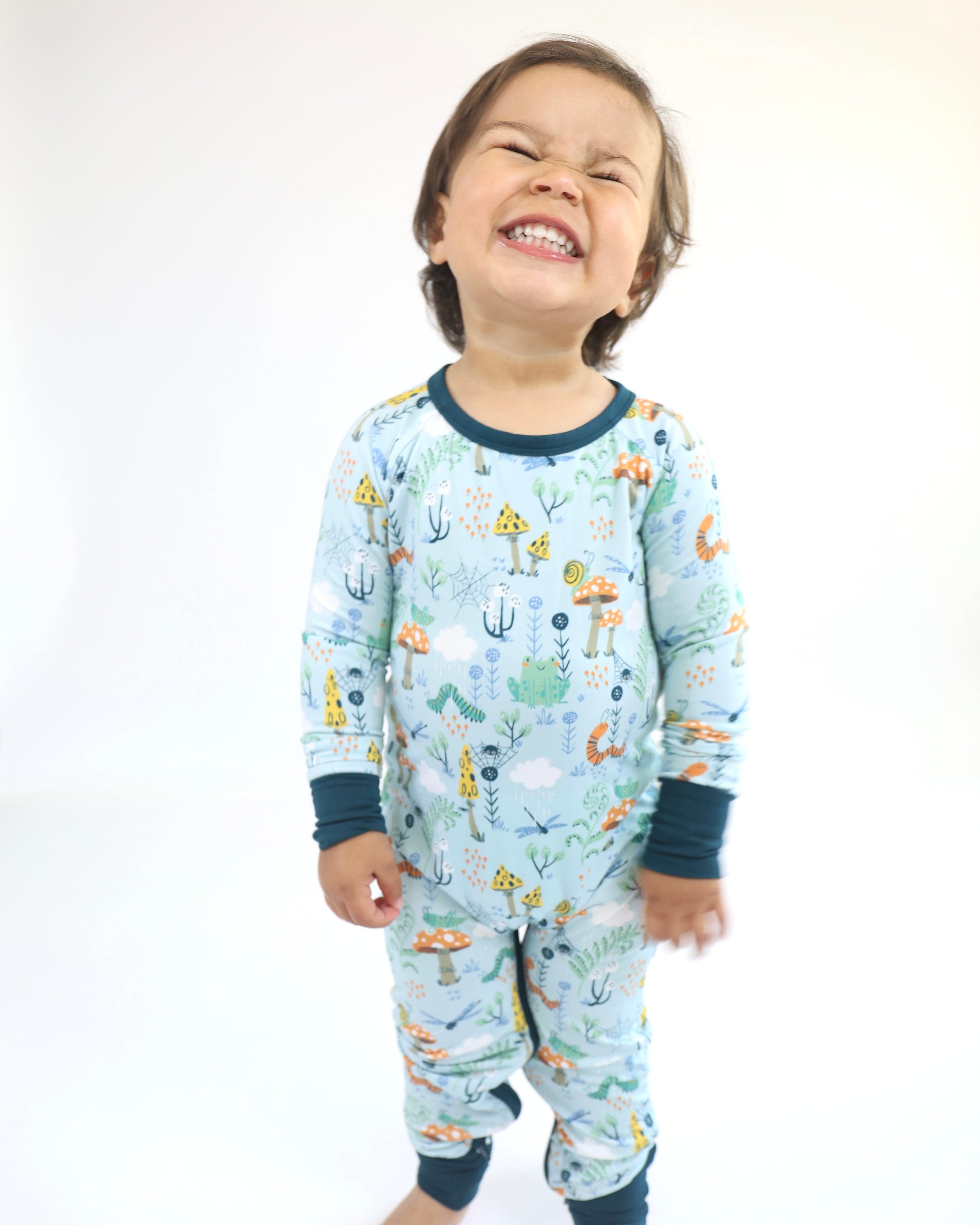 Happy child in Critter Hollow Crescent Zipp Jammies, featuring playful aquatic patterns in breathable bamboo fabric.