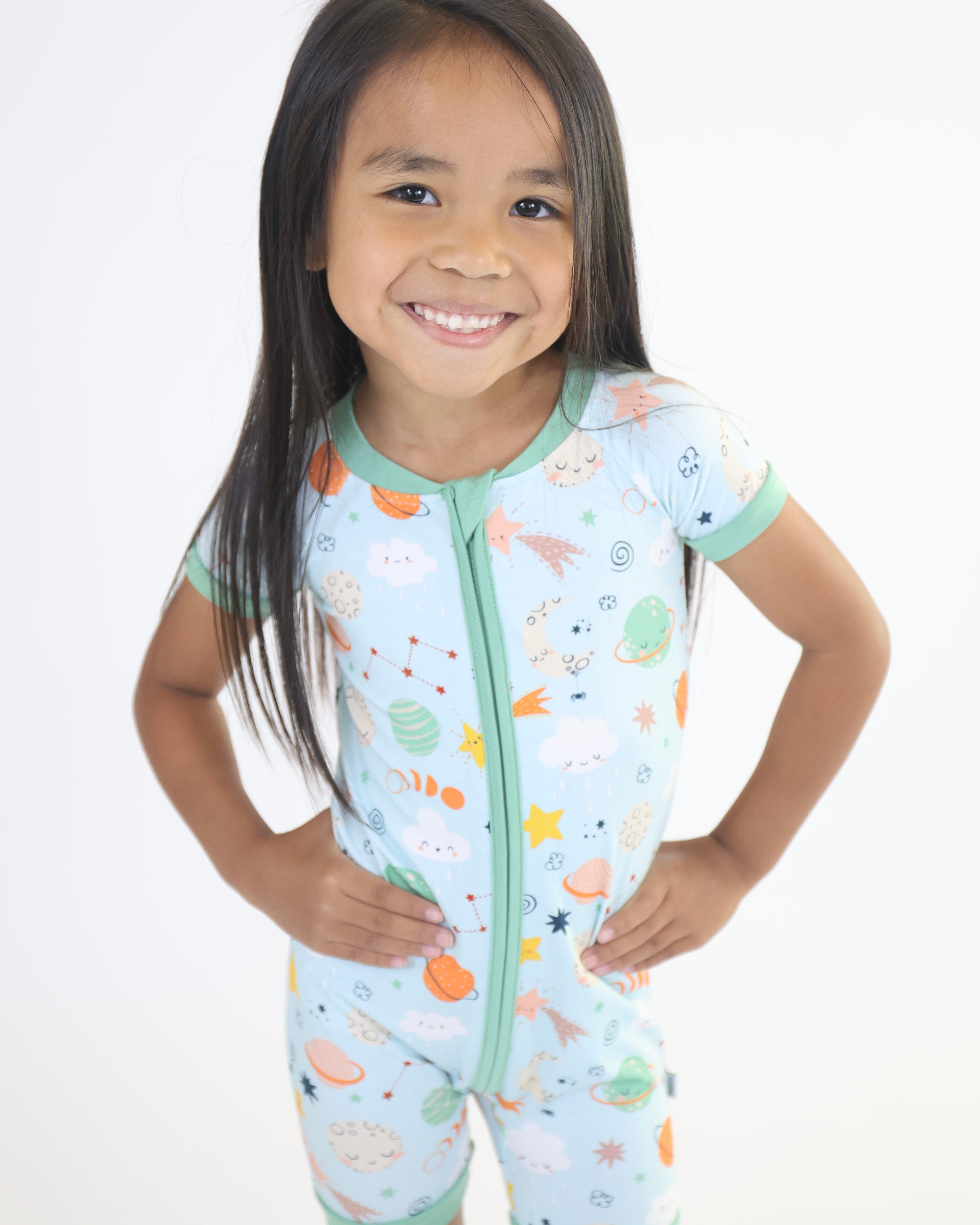 Happy child in Cosmic Short Zipp Romper by Rainn featuring fun space-themed print for comfort and style.