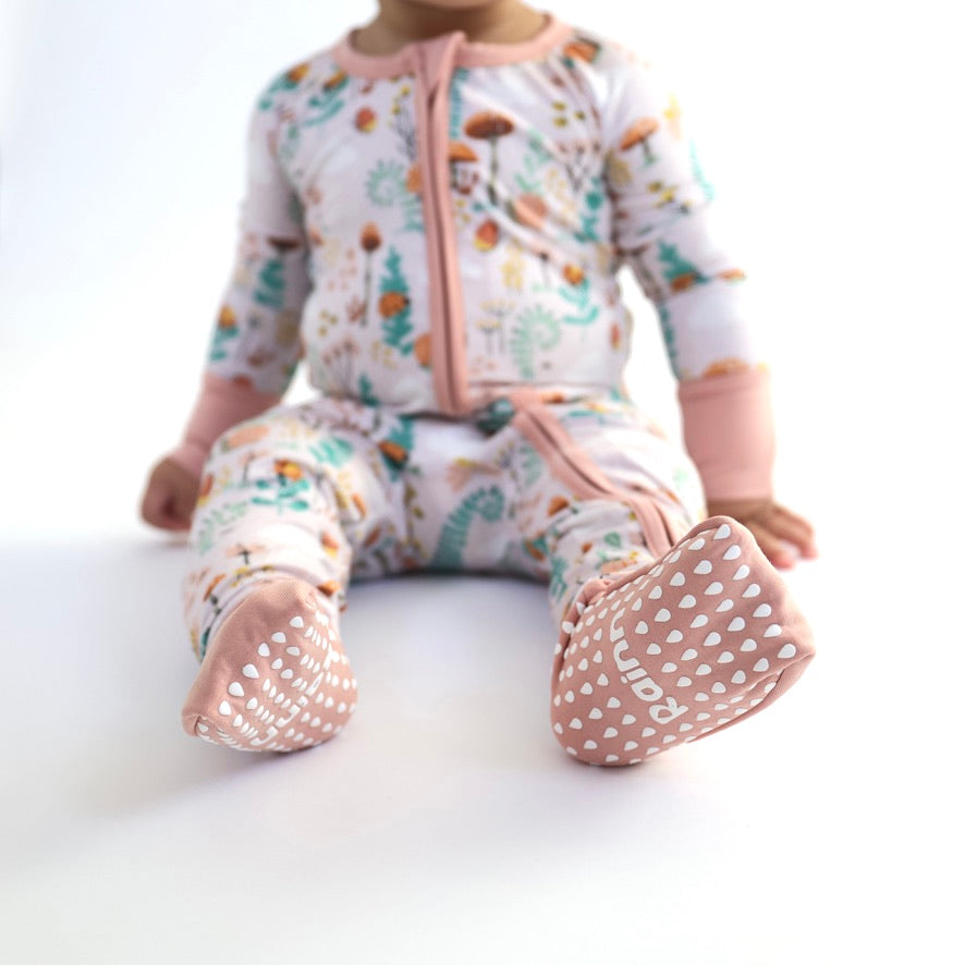 Cute baby in Fern Zipp Jammies by Rainn, featuring playful nature prints and cozy bamboo for comfy sleep.