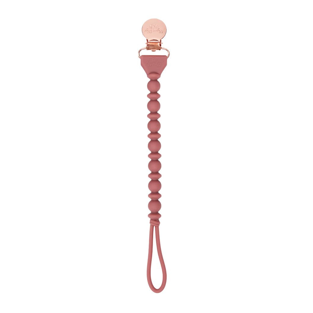 Sweetie Strap™ Silicone Pacifier Clip in blush pink with braided design, perfect for keeping pacifiers secure and stylish.
