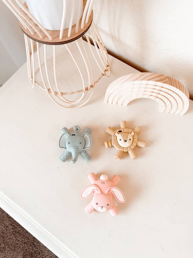 Colorful animal-shaped teethers: elephant, lion, and bunny for baby teething relief.
