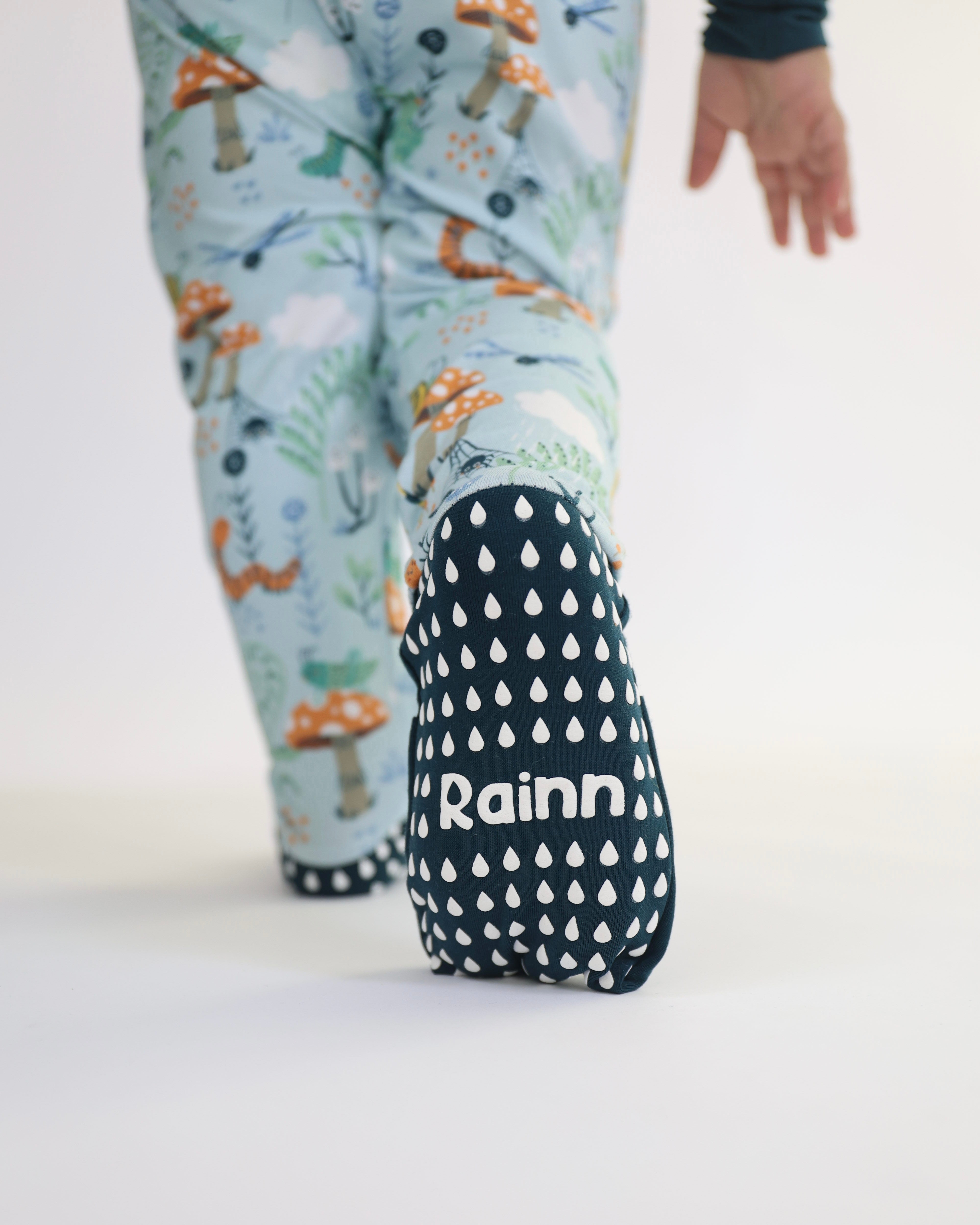 Child wearing Bamboo Zipp Jammies by Rainn with critter print, showcasing non-slip soles. Perfect for sensitive skin and temperature regulation.