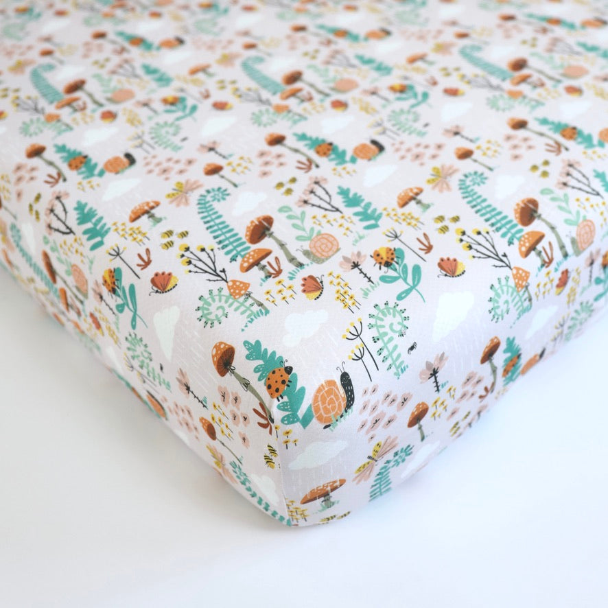 Fern bamboo crib sheet by Rainn with colorful floral and snail pattern, perfect for comfortable baby sleep.