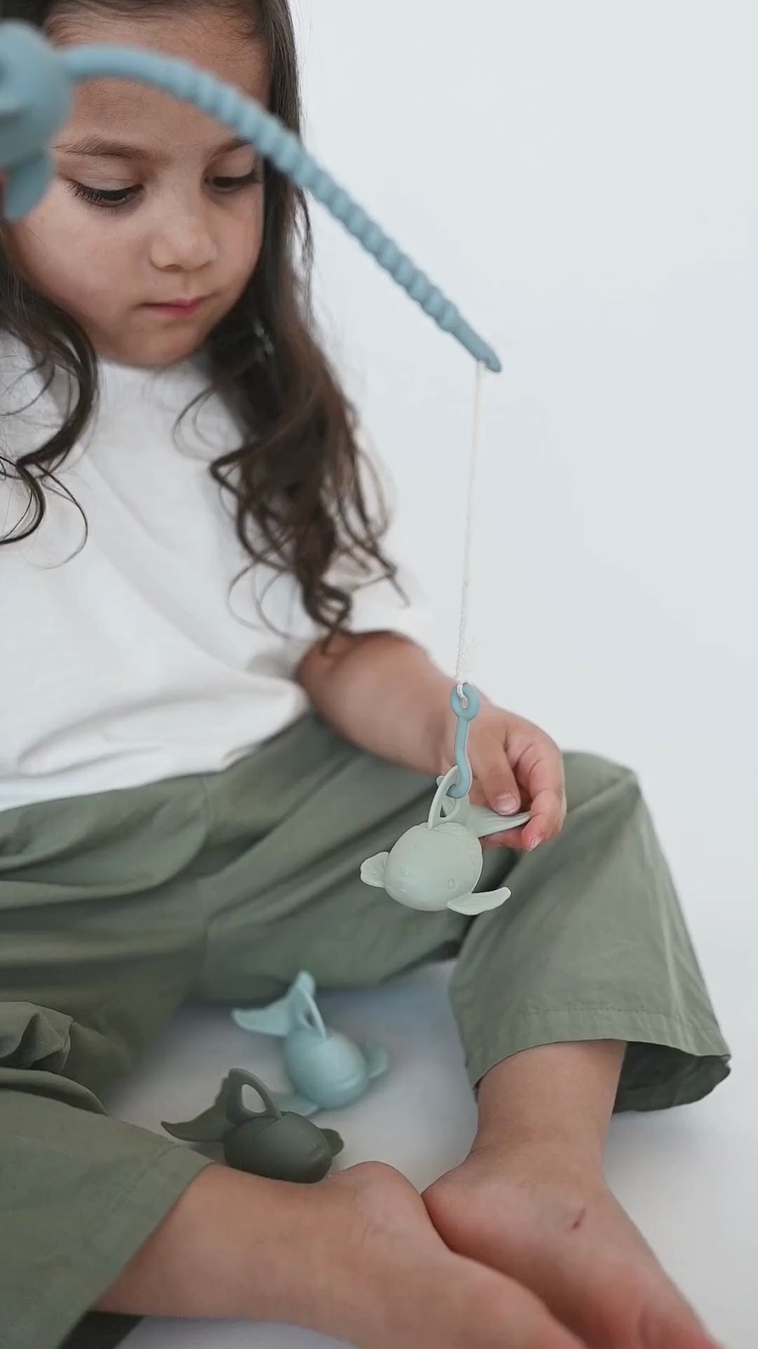 Child playing with Bug + Bean Kids Silicone Fishing Playset, enhancing creativity and motor skills.